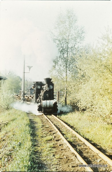 Fotografie Lokomotiva č. 1 u&nbsp;vlakové brány v&nbsp;Mladějově. Kolej doleva vede na výsypku, kde se výklopné dvoukubíkové vozy vyprazdňovaly.