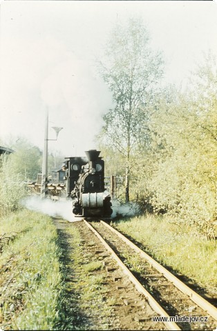 Fotografie Lokomotiva č. 1 u&nbsp;vlakové brány v&nbsp;Mladějově. Kolej doleva vede na výsypku, kde se výklopné dvoukubíkové vozy vyprazdňovaly.