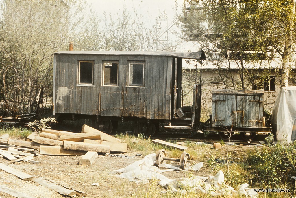 Fotografie Na koleji vedle třídírny stojící původní osobní vůz pro dopravu zaměstnanců z&nbsp;roku 1930, vedle něj pak nářaďový vůz používaný při opravách trati.