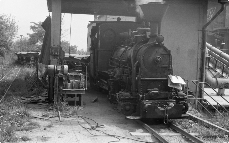 Fotografie Jednička na výsypce přebírá prázdné vozy. Vlevo od lokomotivy je vidět vrátek, kterým se souprava při vykládání posunovala.