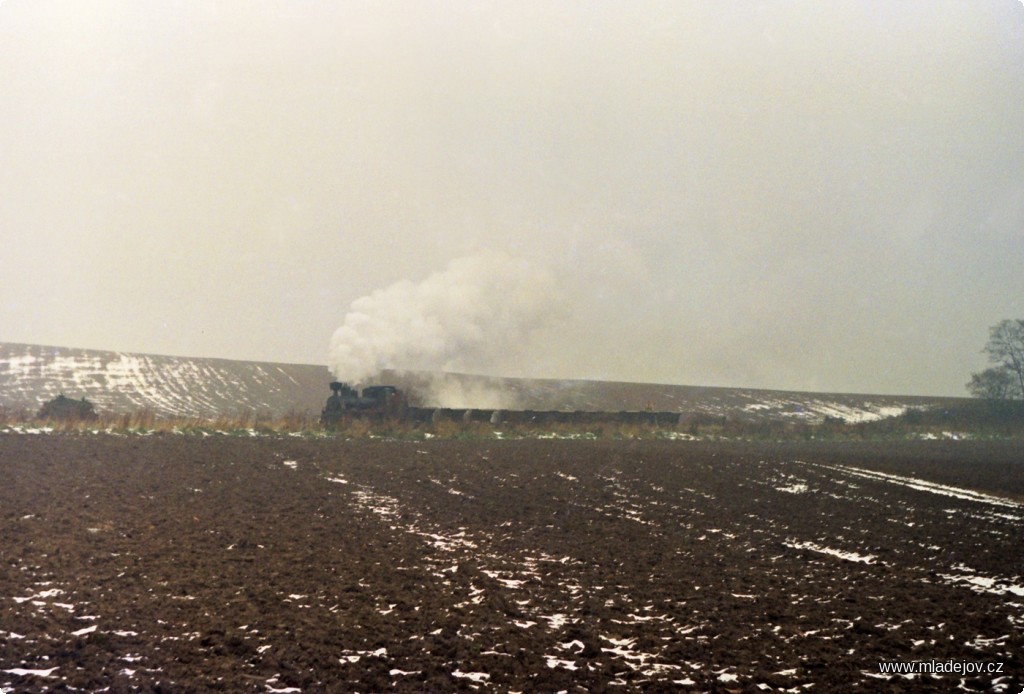 Fotografie Lokomotiva s&nbsp;mnoha vozy sledována objektivy fotografů nad mladějovským zářezem se zásněžkami kolem trati, v&nbsp;roce 1995 už ale nerozestavěnými.