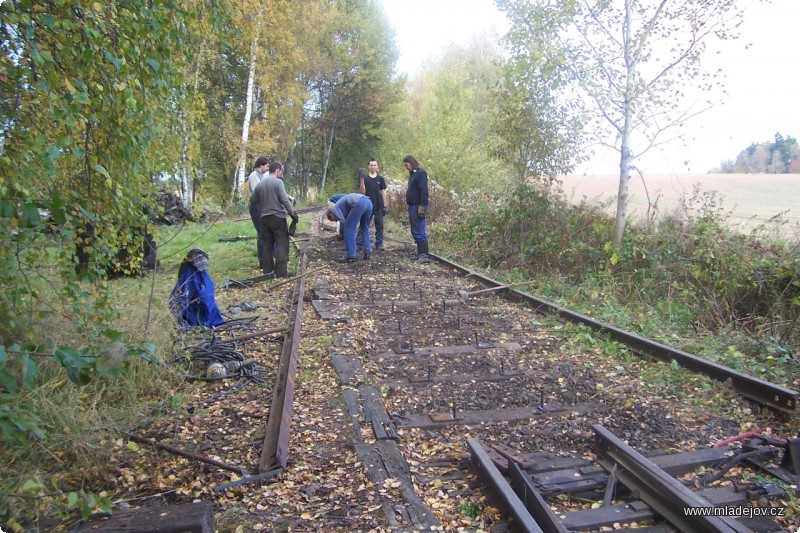 Fotografie Výměna pražců u&nbsp;výjezdu z&nbsp;areálu šamotky. Díky početnější sestavě šla práce rychle od ruky, odpoledne se pokračovalo stejnou činností o&nbsp;necelý půlkilometr dál. 
