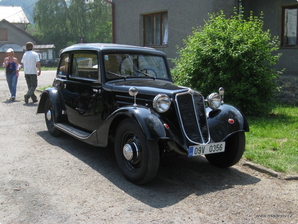 Fotografie Automobil Tatra před správní budovou.
