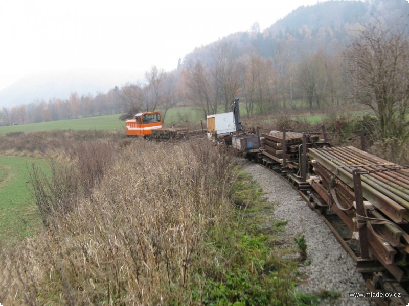 Fotografie Polovina listopadu. Pracovní vlak s&nbsp;nákladem kolejnic, pražců, dalšího materiálu a techniky stoupá z&nbsp;Mladějova na Novou Ves.