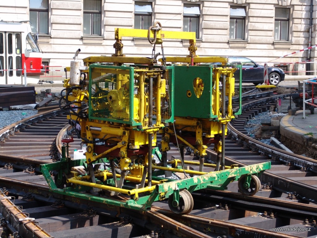 Fotografie Pro srovnání tatáž podbíječka na standardním rozchodu 1435 mm. Na snímku z&nbsp;roku 2010 při opravě tramvajové trati v&nbsp;Myslíkově ulici v&nbsp;Praze.