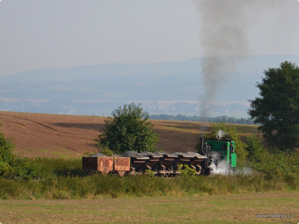 Fotografie Jednička s&nbsp;naloženými vozy štěrku ve stoupání nad mladějovským areálem.