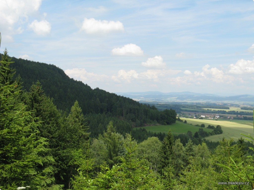 Fotografie Průseky v&nbsp;lese je z&nbsp;prudkého úbočí Hřebečovského hřbetu daleký výhled.
