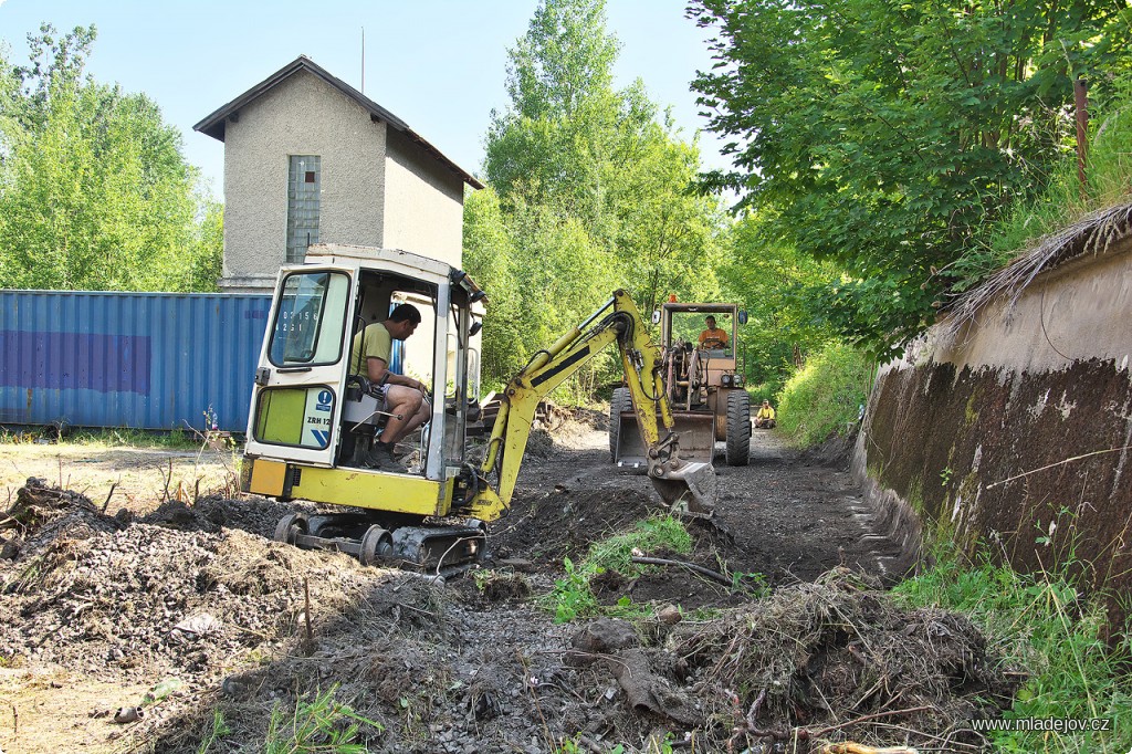 Fotografie Za trhači postupuje bagrovací skupina upravující původní těleso do podoby vhodné ke stavbě.