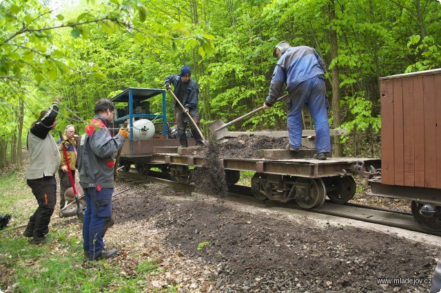 Fotografie Dokončování povrchu cesty dosypáním vytěženého materiálu.